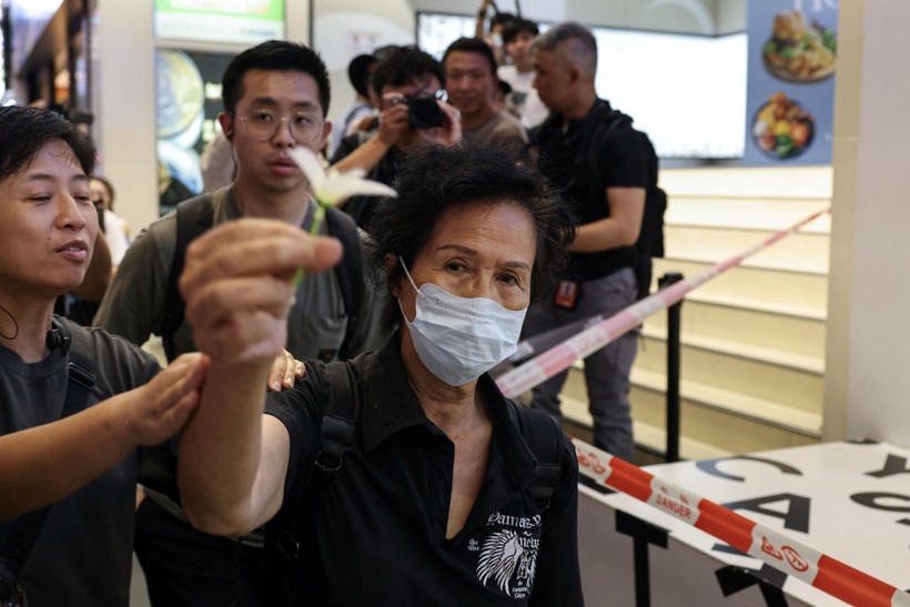 Hong Kong'da Victoria Park'ta bir kadın elinde beyaz çiçek tutuyor.